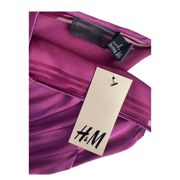 Close-up of a burgundy garment with an H&M tag on a white background
