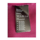 Fabric label with care instructions and material composition on a pink fabric background