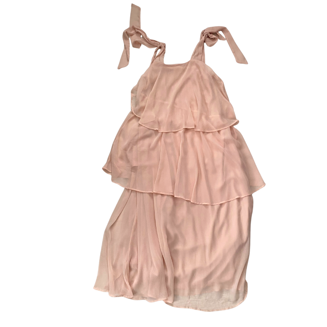 Pink tiered dress with ribbon straps on a white background