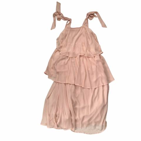 Pink tiered dress with ribbon straps on a white background