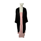 Mannequin wearing a black cardigan over a pink dress on a white background