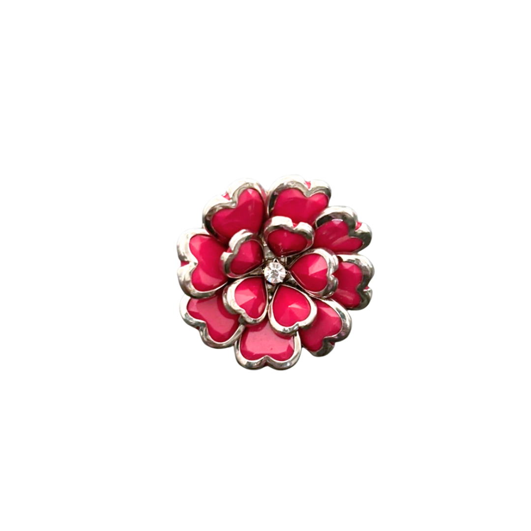 Pink floral cocktail ring with a central gemstone on a white background