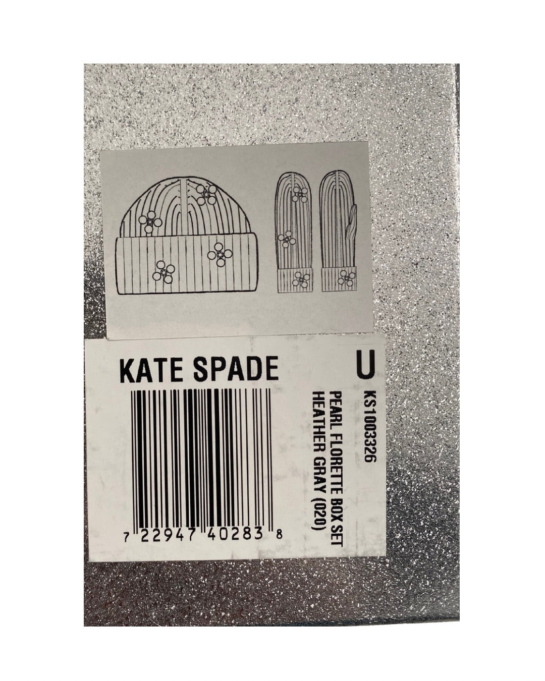 Kate Spade product tag with a hat and glove design on a grey background