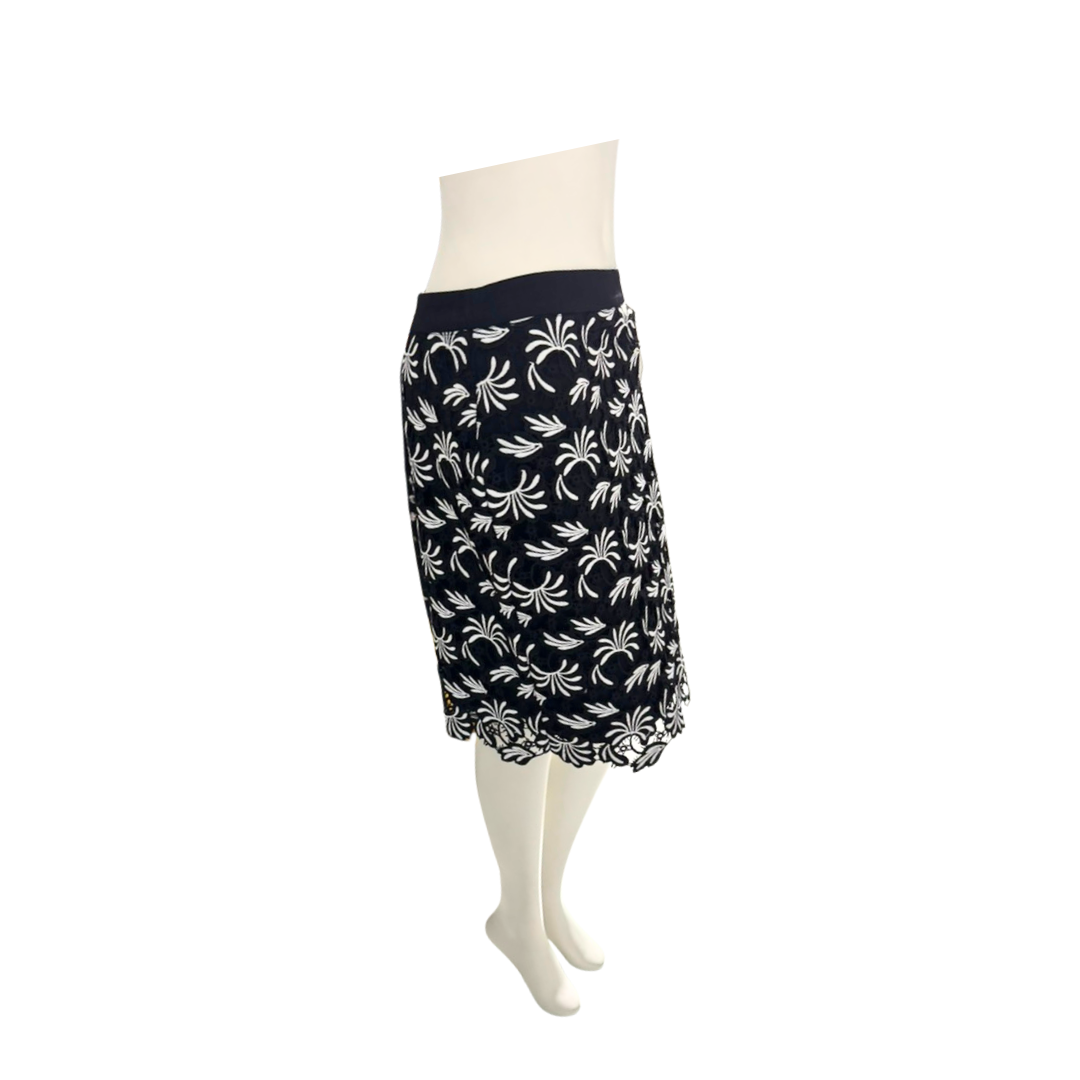 Black skirt with white floral pattern on a mannequin against a white background