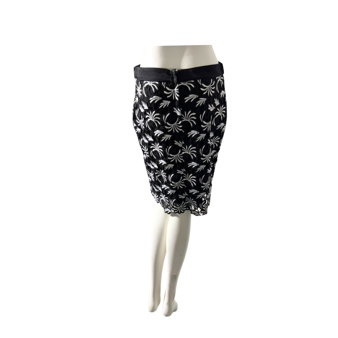 Black skirt with white floral pattern on a mannequin against a white background