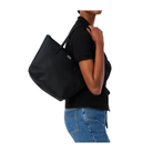 Person wearing a black tote bag on a white background