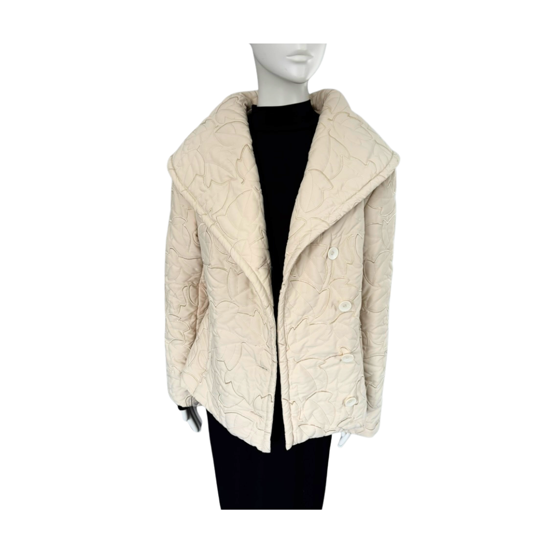 Beige quilted jacket on a mannequin against a white background