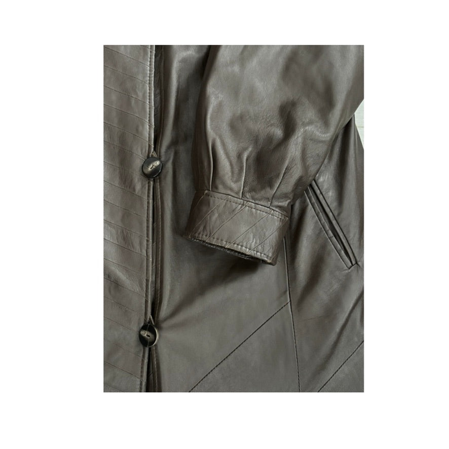 Close-up of a gray leather jacket with buttons and a pocket on a white background