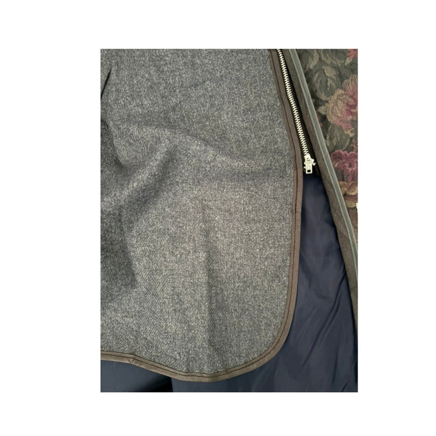 Close-up of a gray textured fabric with a zipper on a white background