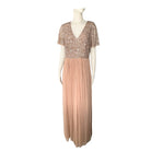 A sequin-embellished taupe maxi dress with a V-neckline, short sleeves, and a pleated tulle skirt, displayed on a mannequin.