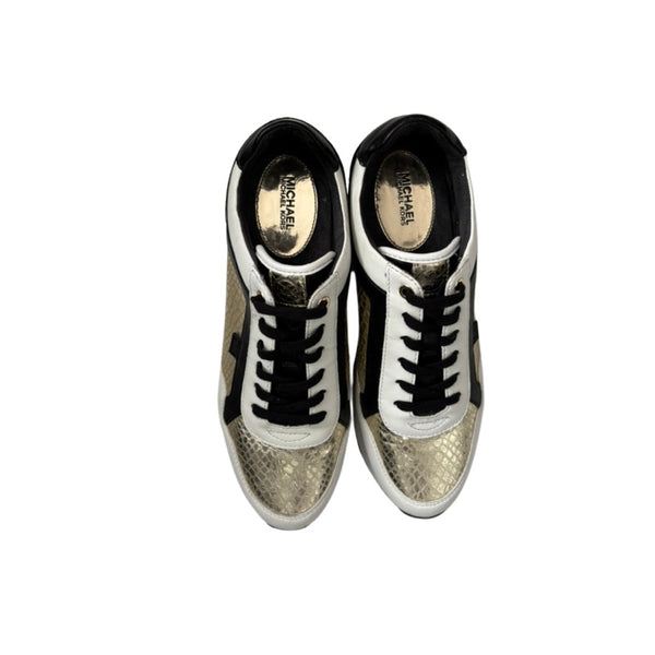 Pair of shiny gold sneakers with black laces on a white background