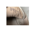 Close-up of a shoe with text on the sole on a light background