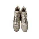 Pair of beige sneakers with white laces on a white background
