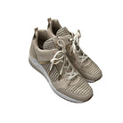 Pair of beige sneakers with white laces on a white background