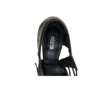 Black sandal with fringe details on a white background