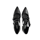 Black high-heeled shoes with strap details on a white background