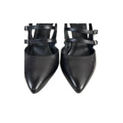Pair of black pointed-toe shoes with strappy design on a white background