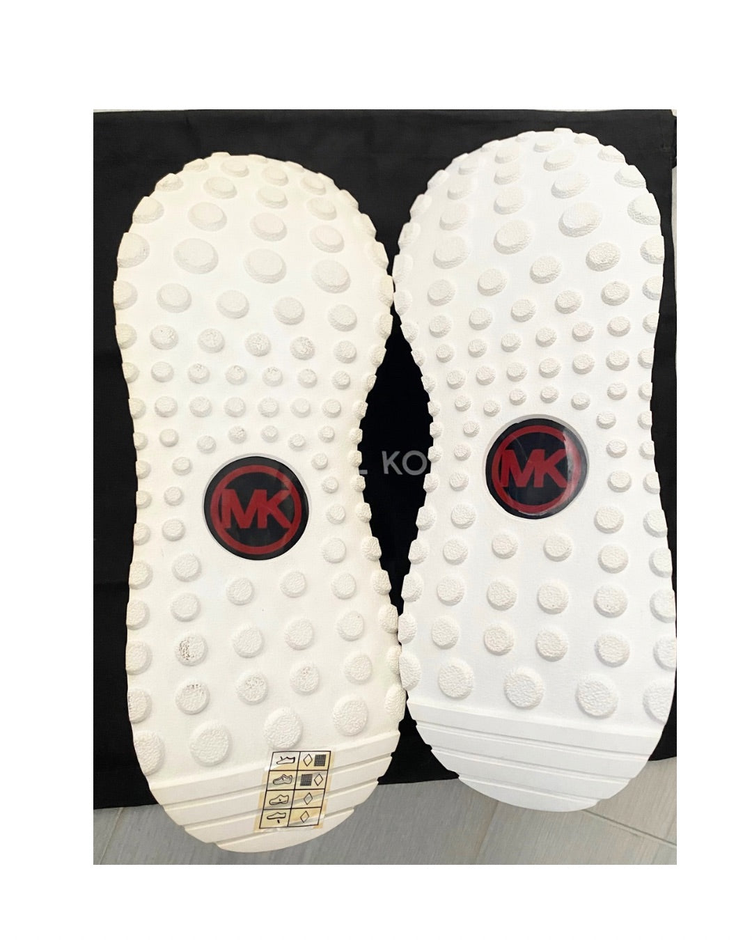 White shoe soles with a brand logo on a black background