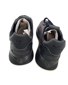 Pair of black sneakers with visible brand logo on a white background