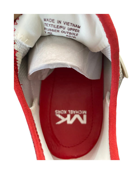Close-up of a red and white shoe with 'MK' branding on the sole.