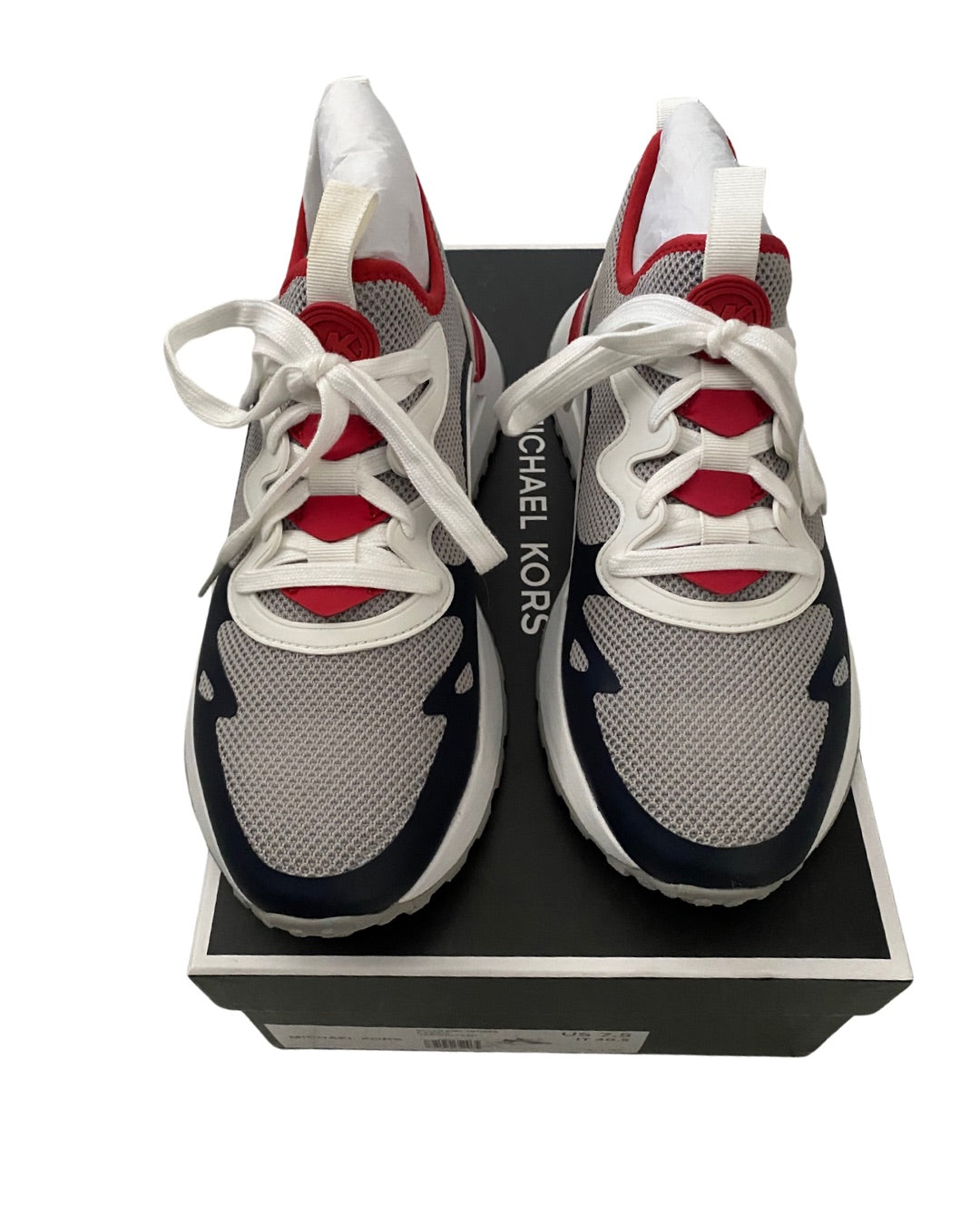 Gray and red sneakers with white laces on a black box, featuring 'Michael Kors' branding.