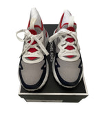 Gray and red sneakers with white laces on a black box, featuring 'Michael Kors' branding.