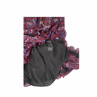 Paisley-patterned fabric  dress hem and black lining underneath on a white background