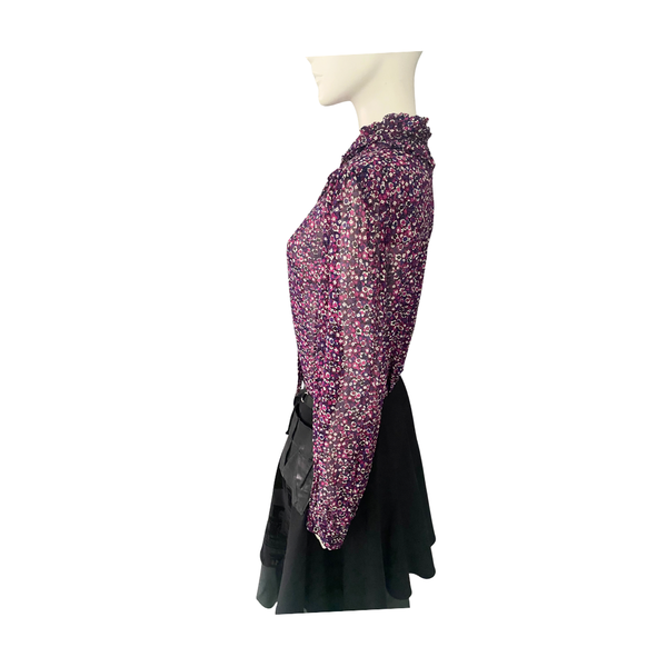 Mannequin wearing  purple patterned top with black skirt on a white background