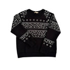 Black sweater with white pattern and grommets on a white background