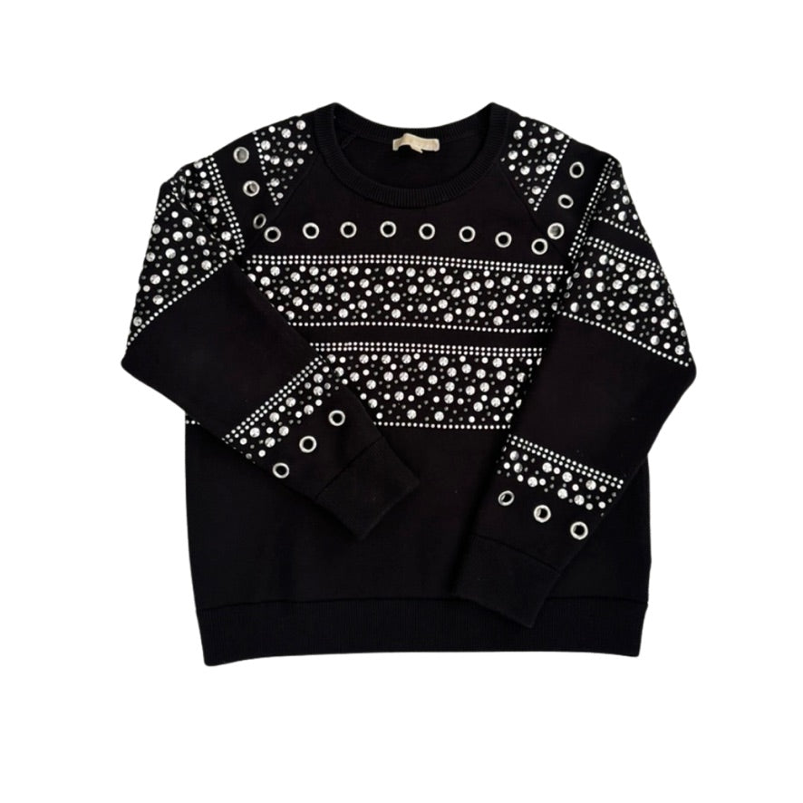 Black sweater with white pattern and grommets on a white background