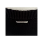 Black knit sweater with a visible brand label on a white background
