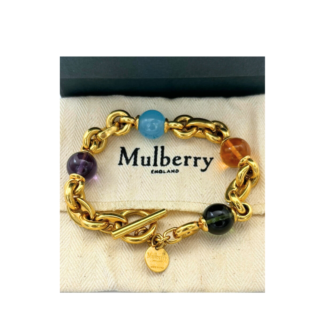 Gold chain bracelet with colored beads on a Mulberry branded card