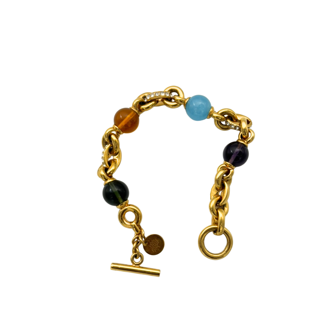 Gold bracelet with colored beads on a white background