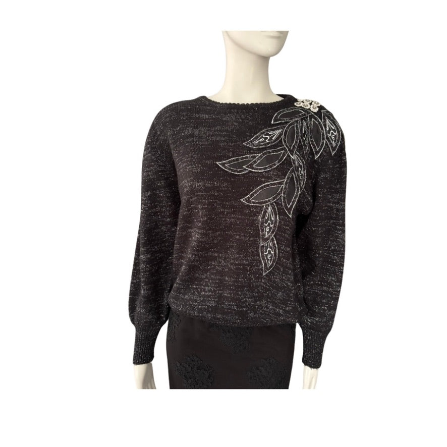 Dark gray sweater with leaf design on a mannequin against a white background