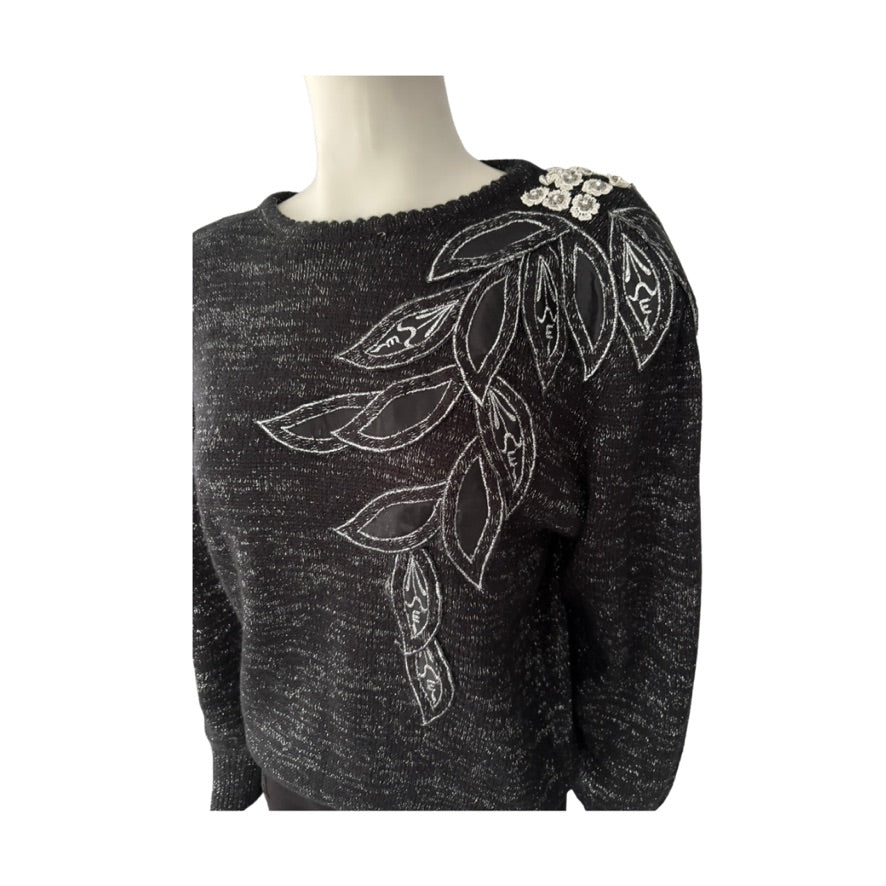 Grey sweater with white leaf patterns on a mannequin against a white background