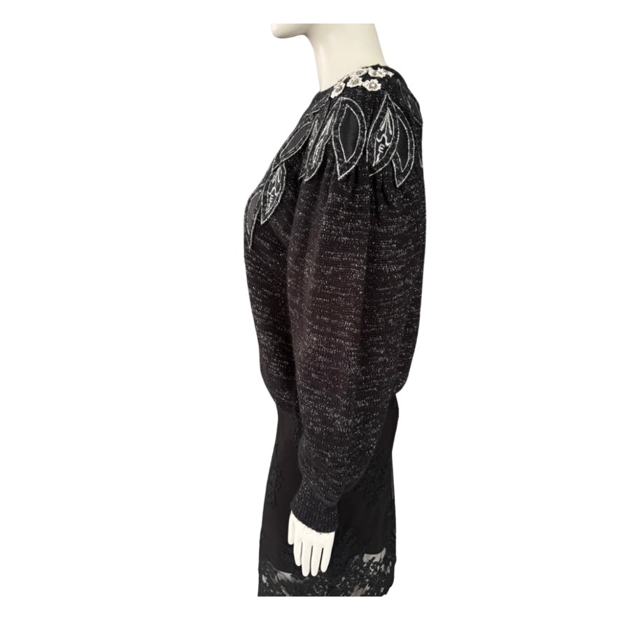 Black textured dress with floral embellishments on a white background