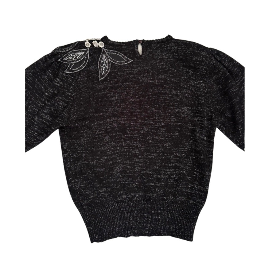Black sweater with floral embroidery on a white background