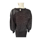 Black sweater with decorative elements on a mannequin against a white background