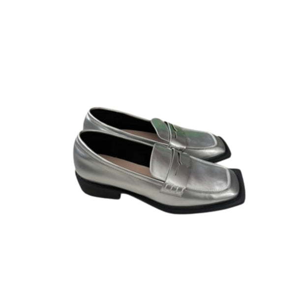 Silver loafers with a strap on a white background