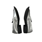 Pair of silver high-heeled shoes with black soles on a white background