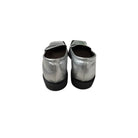 Pair of silver metallic shoes with black soles on a white background