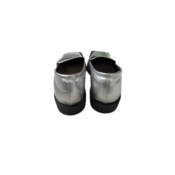 Pair of silver metallic shoes with black soles on a white background