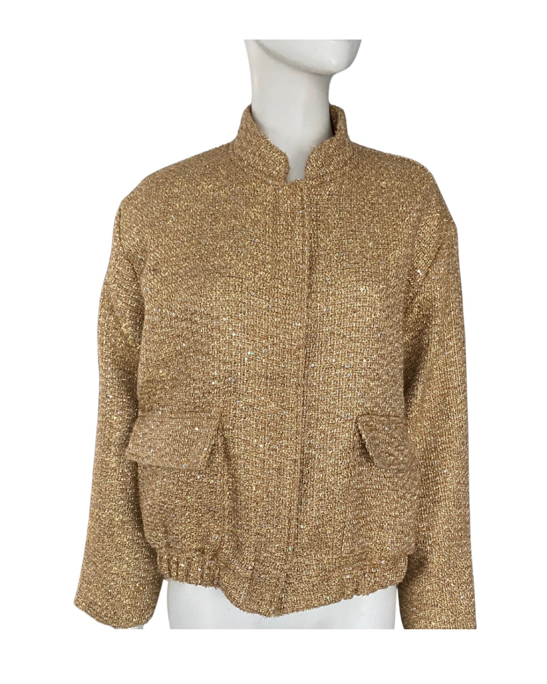 Gold knit cardigan on a mannequin against a white background