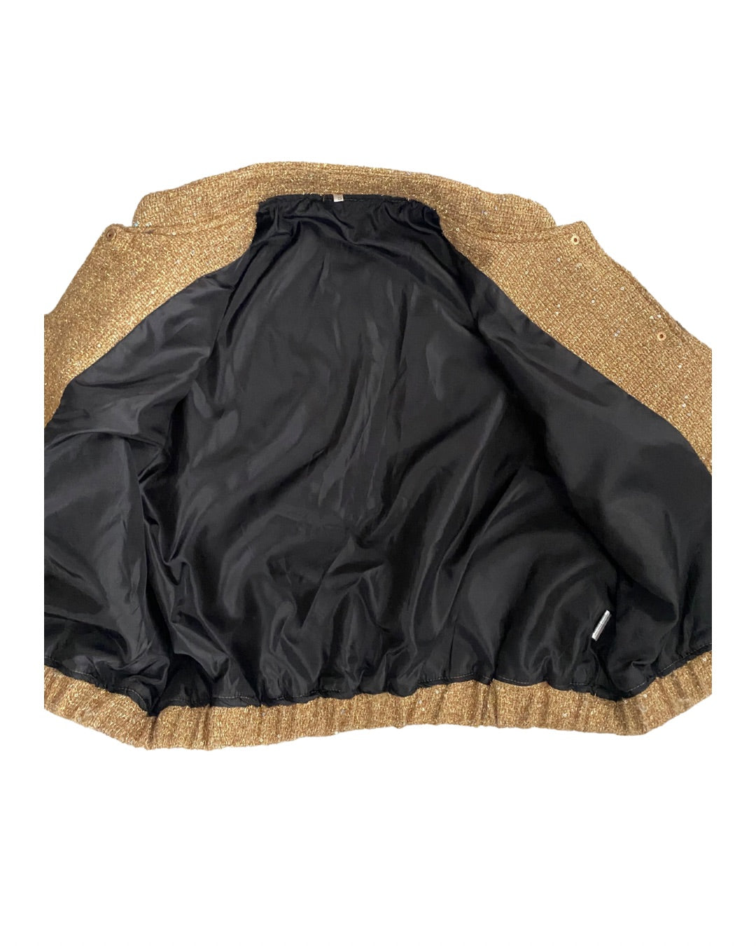 Close-up of a jacket with black lining and beige or brown trim on a white background