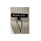 Close-up of a Michael Kors label on a beige knitted sweater.