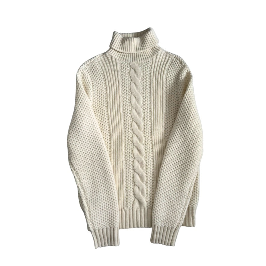 White turtleneck sweater with cable knit pattern on a white background