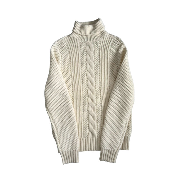 White turtleneck sweater with cable knit pattern on a white background