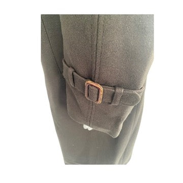 Close-up of a brown belt buckle on a gray pants pocket against a white background