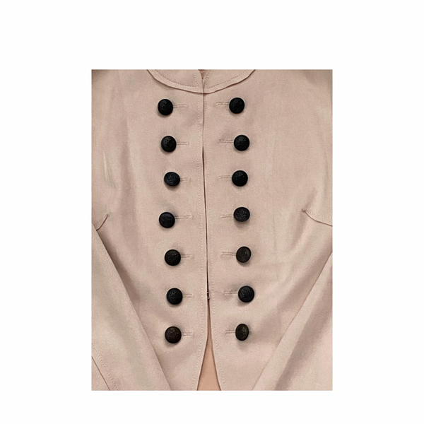 Close-up of a pale pink jacket  with black buttons on a white background