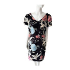 Black dress with colorful floral and abstract patterns on a mannequin against a white background